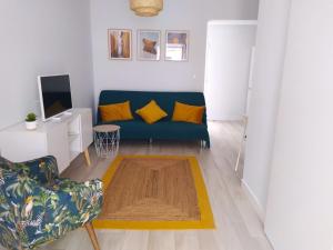 een woonkamer met een blauwe bank en gele kussens bij Casa Belice in Vila Real de Santo António