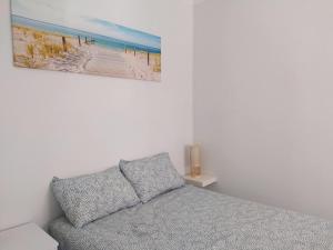 a bedroom with a bed and a picture of a beach at Casa Belice in Vila Real de Santo António