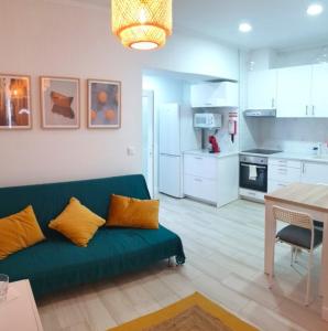 een woonkamer met een groene bank en een keuken bij Casa Belice in Vila Real de Santo António