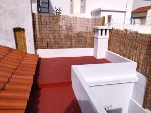 een balkon met een rode vloer en een houten hek bij Casa Belice in Vila Real de Santo António