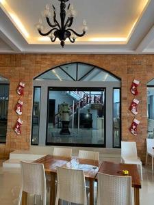 a dining room with a table and chairs and a chandelier at Oval era mall hotel condo suites in Bangued