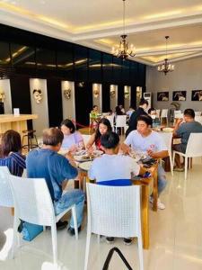 un grupo de personas sentadas en mesas comiendo comida en Oval era mall hotel condo suites, en Bangued