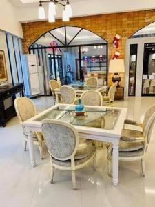 a dining room with a white table and chairs at Oval era mall hotel condo suites in Bangued