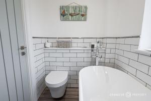 uma casa de banho com um WC, um lavatório e uma banheira em Tranquil 3-Bedroom Haven in Lymington - The Herons Nest em Lymington