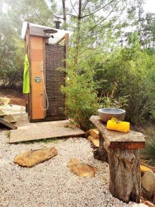 a outdoor shower with a stone bowl on a stump at Costa Vicentina Sky View in Rogil