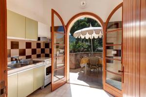 kuchnia z otwartymi drzwiami prowadzącymi na patio w obiekcie Le Residenze di Piazza Italia w mieście Costa Rei
