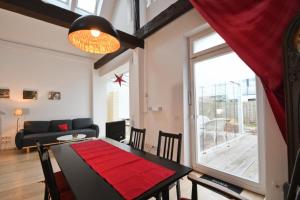 a living room with a dining room table with a red rug at Packhaus Norderney in Norderney