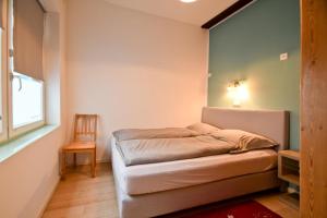 a small bedroom with a bed and a chair at Packhaus Norderney in Norderney