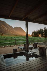 two chairs on a porch with a view of a field at Hemel 'N Aarde Stud in Hermanus