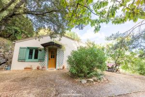 uma pequena casa branca com uma porta amarela em Le Petit Paradis em Prémian