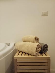 un montón de toallas sentadas en una mesa de madera en el baño en Decumano 23, en Nápoles