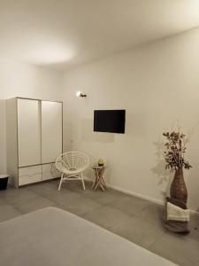 Habitación blanca con TV en la pared en Decumano 23, en Nápoles