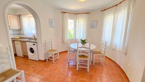 een keuken en eetkamer met een tafel en stoelen bij Villas Molins - BTB in Denia