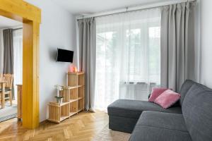 uma sala de estar com um sofá e uma grande janela em Rent like home - Krzeptowskiego em Zakopane