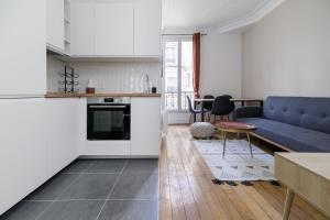 una cucina e un soggiorno con divano blu di Bridgestreet - Opera Montmartre a Parigi