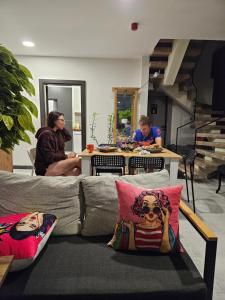duas pessoas sentadas numa mesa numa sala de estar em Oldskool Villas em Lara