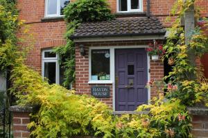 een paarse deur op een bakstenen huis met planten bij Haydn House in Glastonbury