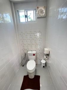 a white bathroom with a toilet and a window at PICHAPON RESORT in Pak Chong +28 photos