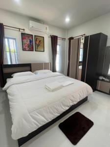 Un dormitorio con una cama grande con sábanas blancas. en PICHAPON RESORT, en Pak Chong 28 fotos más