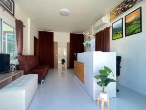 a living room with a couch and a tv at PICHAPON RESORT in Pak Chong