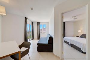 a bedroom with a bed and a chair and a desk at Mirador Maspalomas by Dunas in Maspalomas