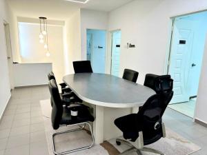 a conference room with a table and black chairs at Three Homestay in Perai +49 photos