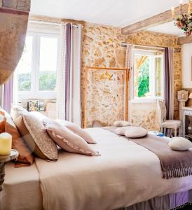 ein Schlafzimmer mit einem großen Bett mit Kissen darauf in der Unterkunft Au Clair de Vianne in Vianne