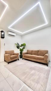 two brown couches in a living room at Three Homestay in Perai