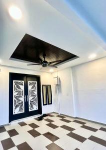 a room with a ceiling fan and a checkered floor at Three Homestay in Perai