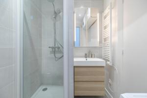 bagno bianco con doccia e lavandino di Bridgestreet - Opera Montmartre a Parigi