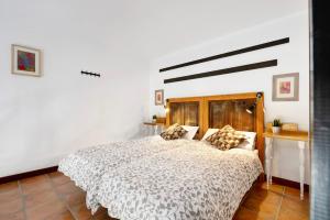 een slaapkamer met een groot bed met een houten hoofdeinde bij Finca Emblemática - Nº3 Liria in La Vegueta +18 foto's