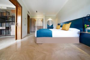 a bedroom with a large bed with a blue headboard at Suites & Villas by Dunas in Maspalomas