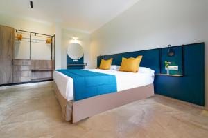 a bedroom with a large bed with a blue wall at Suites & Villas by Dunas in Maspalomas