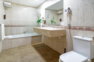 a bathroom with a sink and a toilet at Suites & Villas by Dunas in Maspalomas