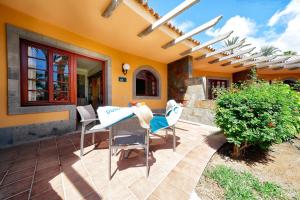 a patio with chairs and a table in front of a house at Suites & Villas by Dunas in Maspalomas