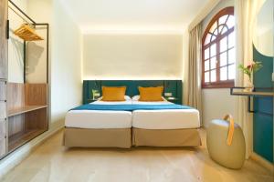 a bedroom with a king sized bed with orange pillows at Suites & Villas by Dunas in Maspalomas