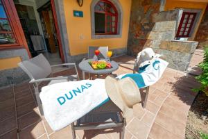 a patio with a table and chairs with a meal on it at Suites & Villas by Dunas in Maspalomas