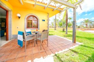 a patio with a table and chairs in front of a house at Suites & Villas by Dunas in Maspalomas
