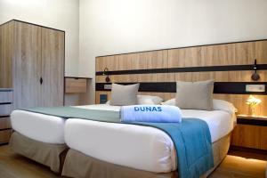 a bedroom with a large bed with a large headboard at Suites & Villas by Dunas in Maspalomas