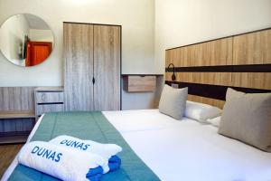 a bedroom with a bed with two pillows on it at Suites & Villas by Dunas in Maspalomas