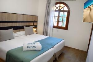 a bedroom with a bed with two pillows on it at Suites & Villas by Dunas in Maspalomas