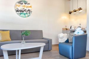 a living room with a couch and a table and a chair at Suites & Villas by Dunas in Maspalomas