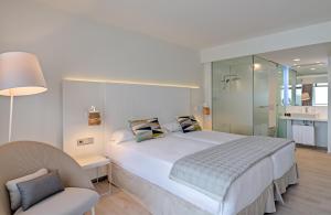 a bedroom with a large white bed and a chair at Don Gregory by Dunas - Adults Only in San Agustin