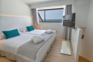 a bedroom with two beds and a flat screen tv at Don Gregory by Dunas - Adults Only in San Agustin