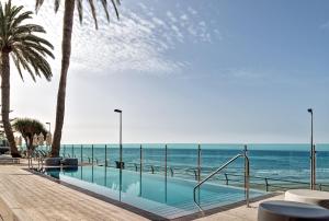 a swimming pool with the ocean in the background at Don Gregory by Dunas - Adults Only in San Agustin