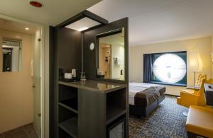 um quarto de hotel com uma cama e um espelho em ARCOTEL Onyx Hamburg em Hamburgo