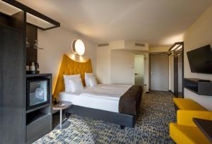 a hotel room with a bed and a television at ARCOTEL Onyx Hamburg in Hamburg