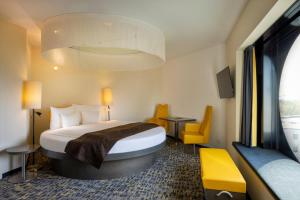 a hotel room with a bed and a yellow chair at ARCOTEL Onyx Hamburg in Hamburg