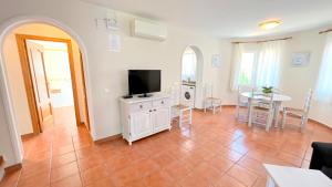 een woonkamer met een flatscreen-tv en een tafel bij Villas Molins - BTB in Denia