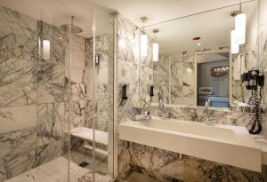 a bathroom with a sink and a shower at ARCOTEL Onyx Hamburg in Hamburg +45 photos